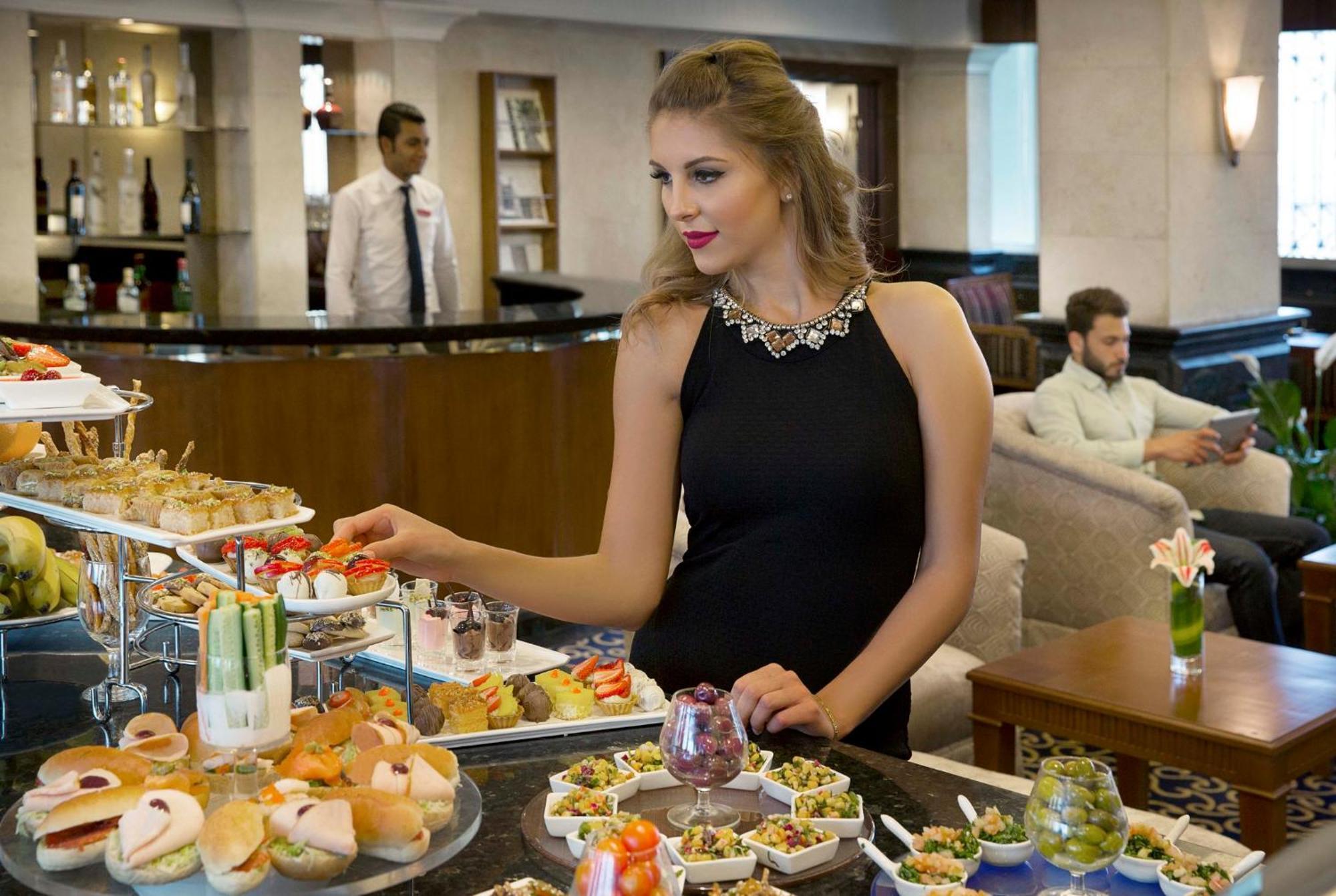 Crowne Plaza Amman By Ihg Hotel Eksteriør billede A woman selecting food from a buffet